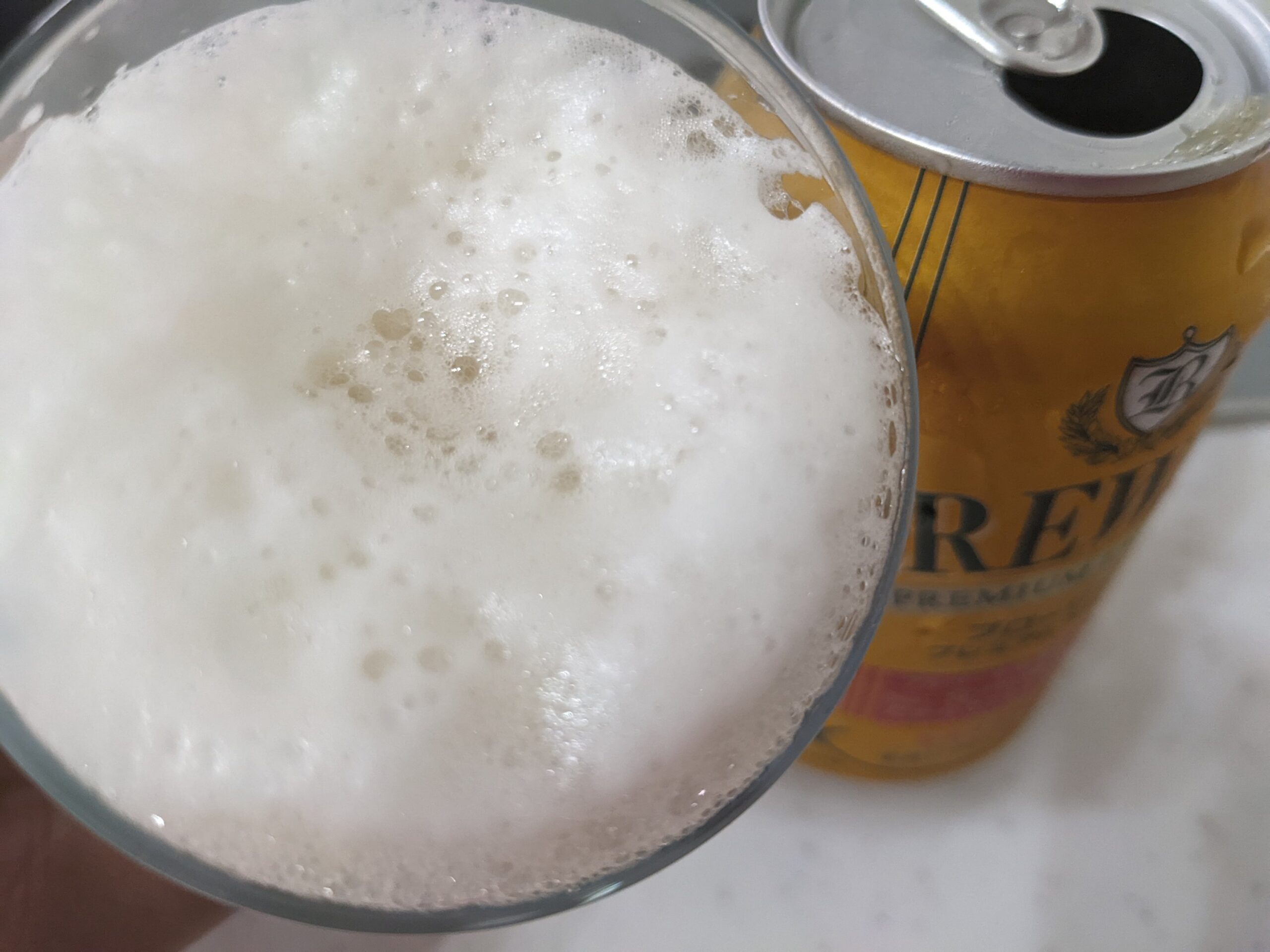グラスに注がれた「ブローリープレミアムラガー」を飲むところ