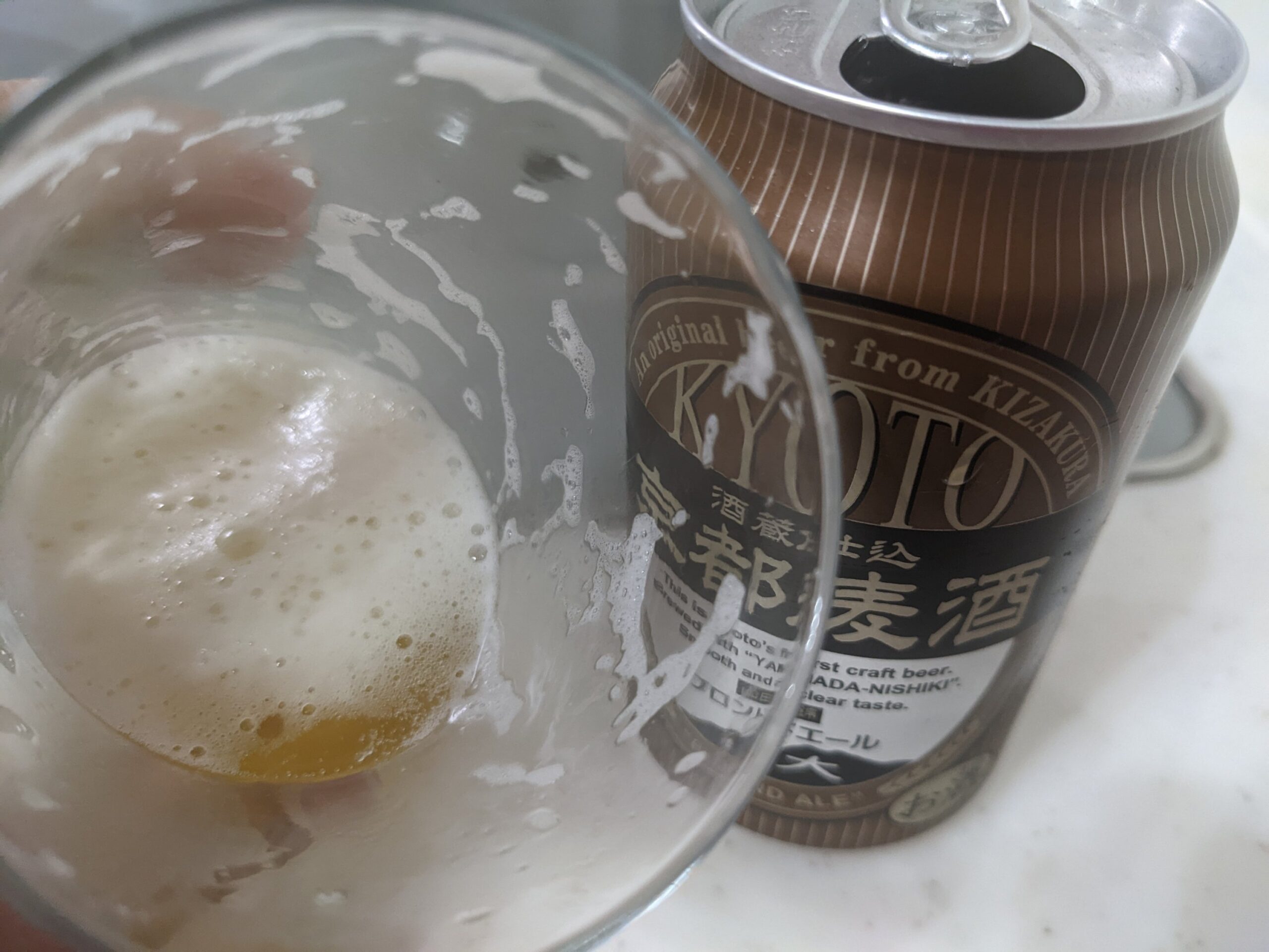 残り2割程の「京都麦酒ブロンドエール」を手前に傾けているところ
