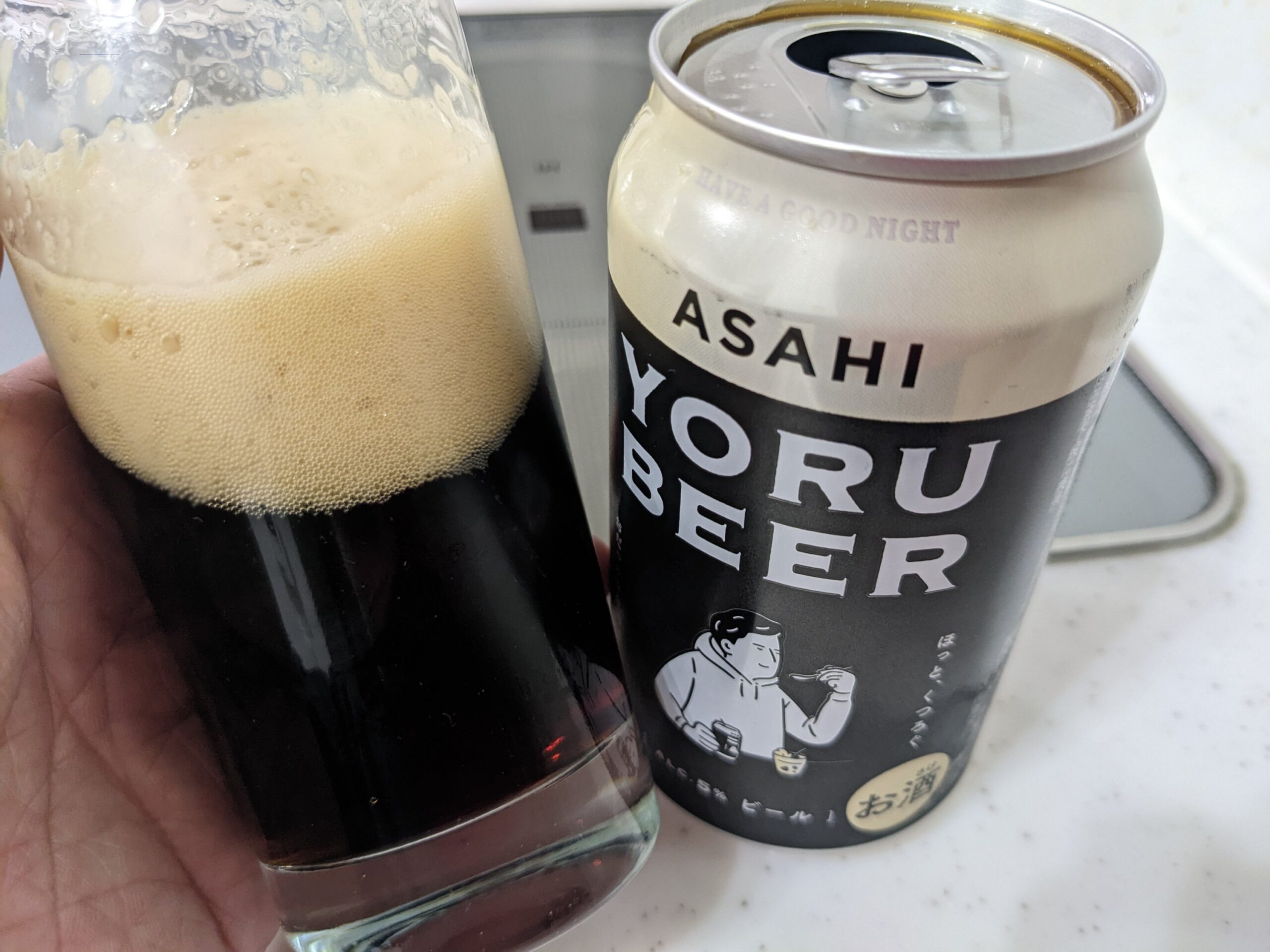 グラスに入ったアサヒ「YORU BEER(ヨルビール)」を傾けているところ