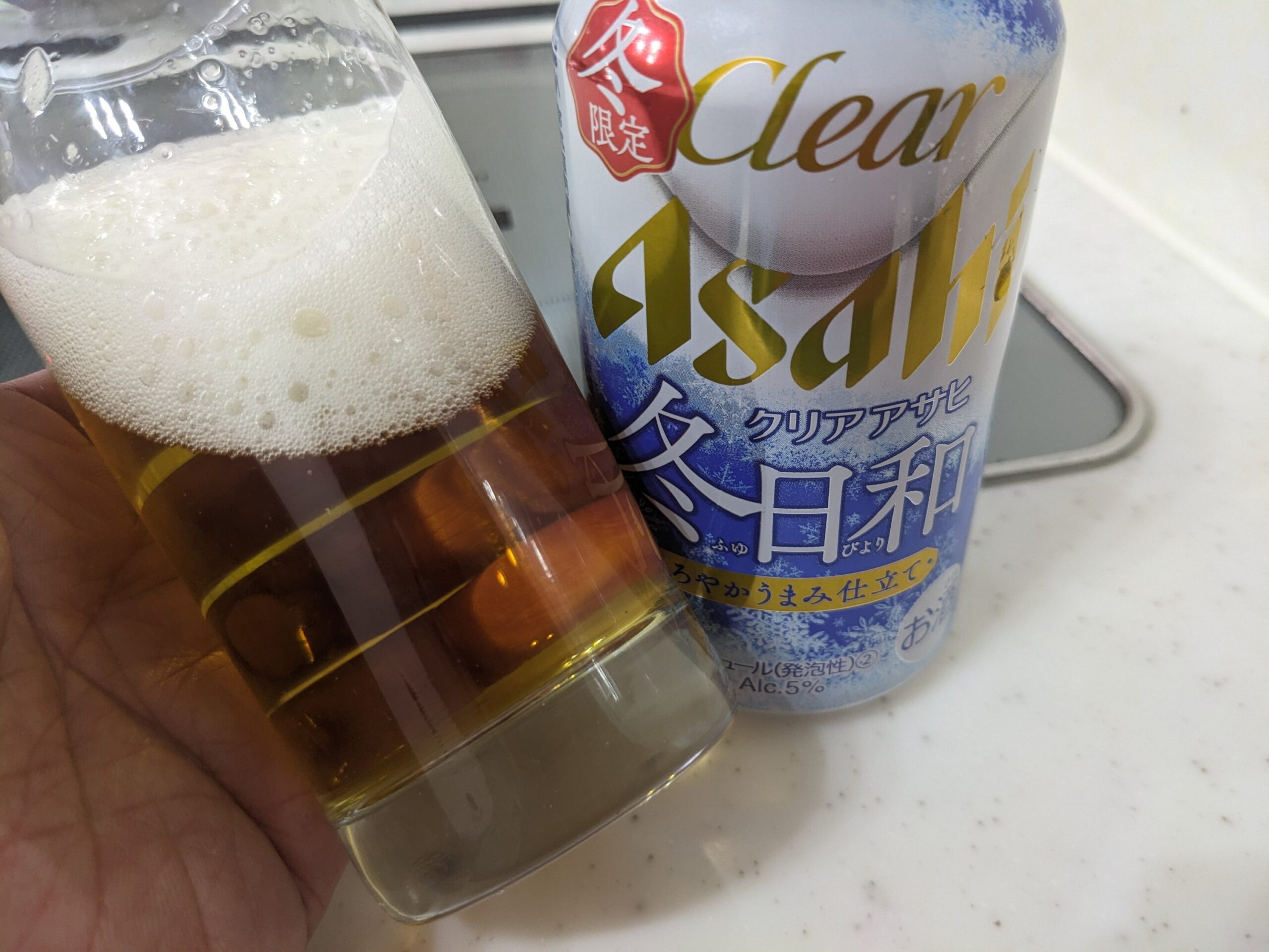 「クリアアサヒ冬日和」が入ったグラスを傾けているところ