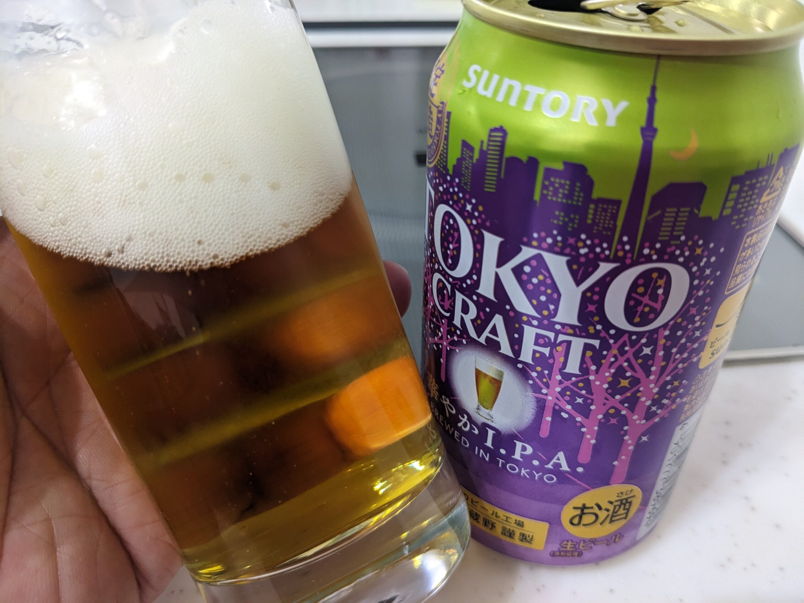 「東京クラフト華やかI.P.A.」が入ったグラスを傾けているところ
