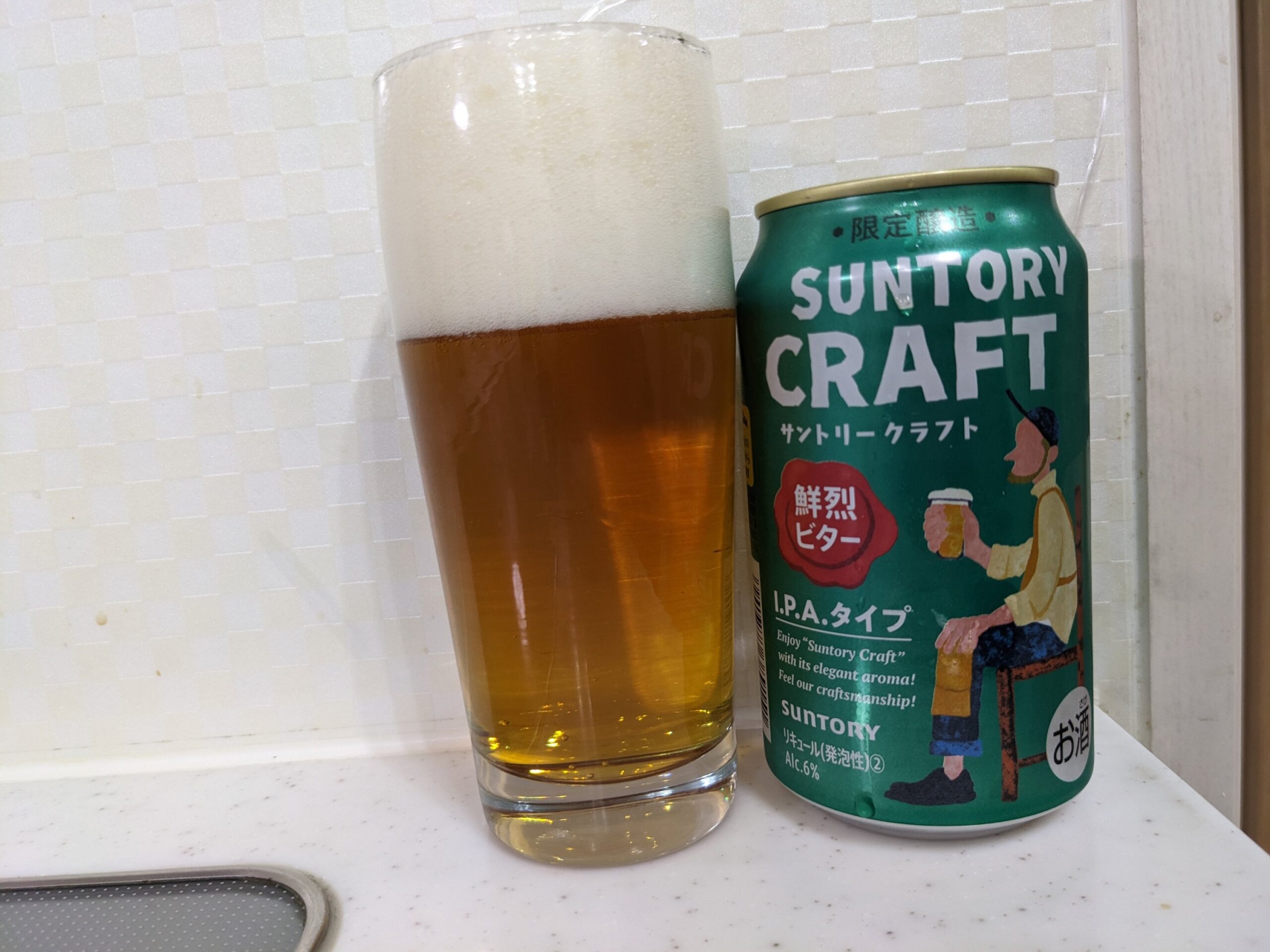 「サントリークラフト鮮烈ビター」が注がれたグラスとその缶
