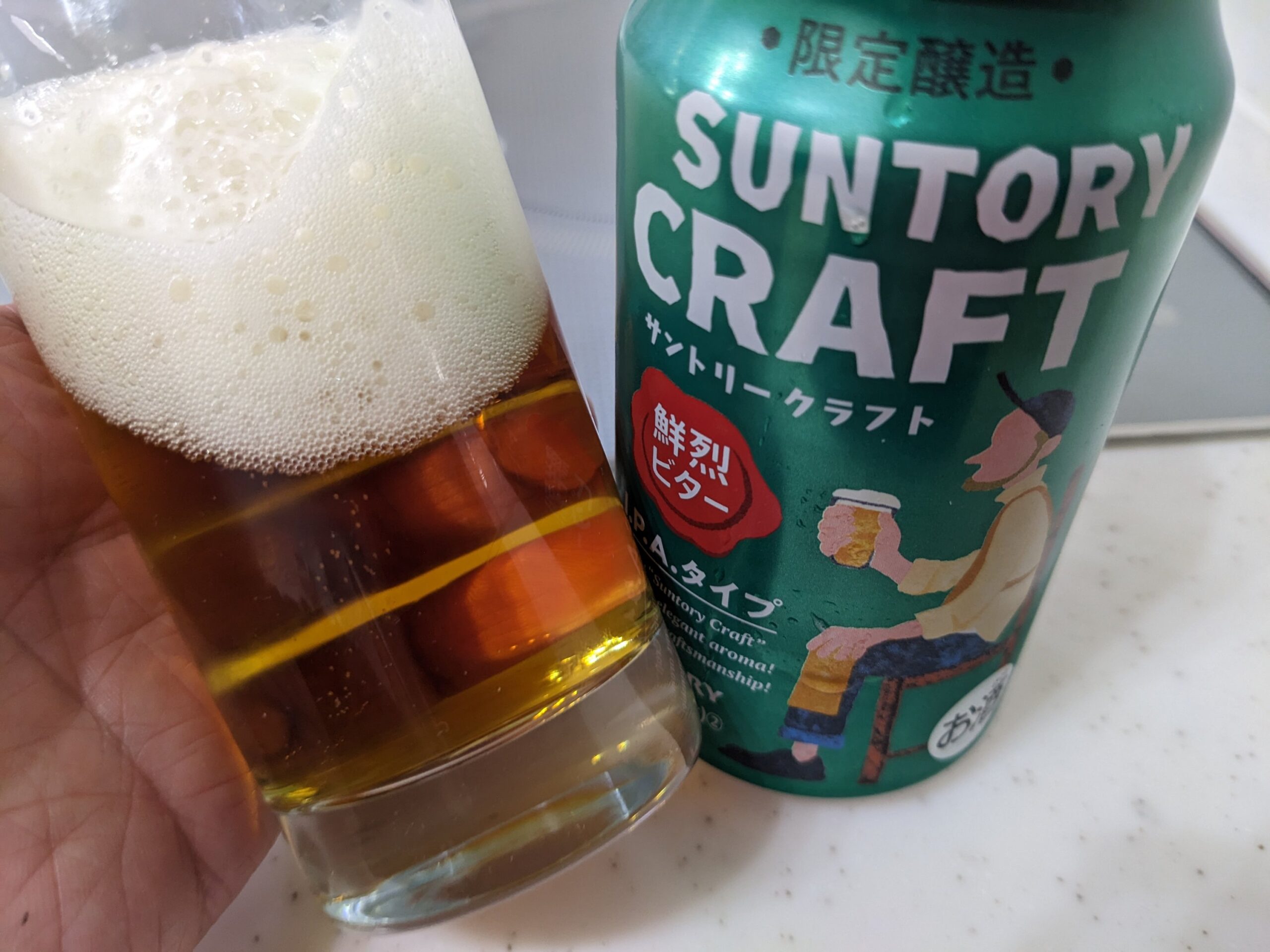 「サントリークラフト鮮烈ビター」が入ったグラスを傾けているところ