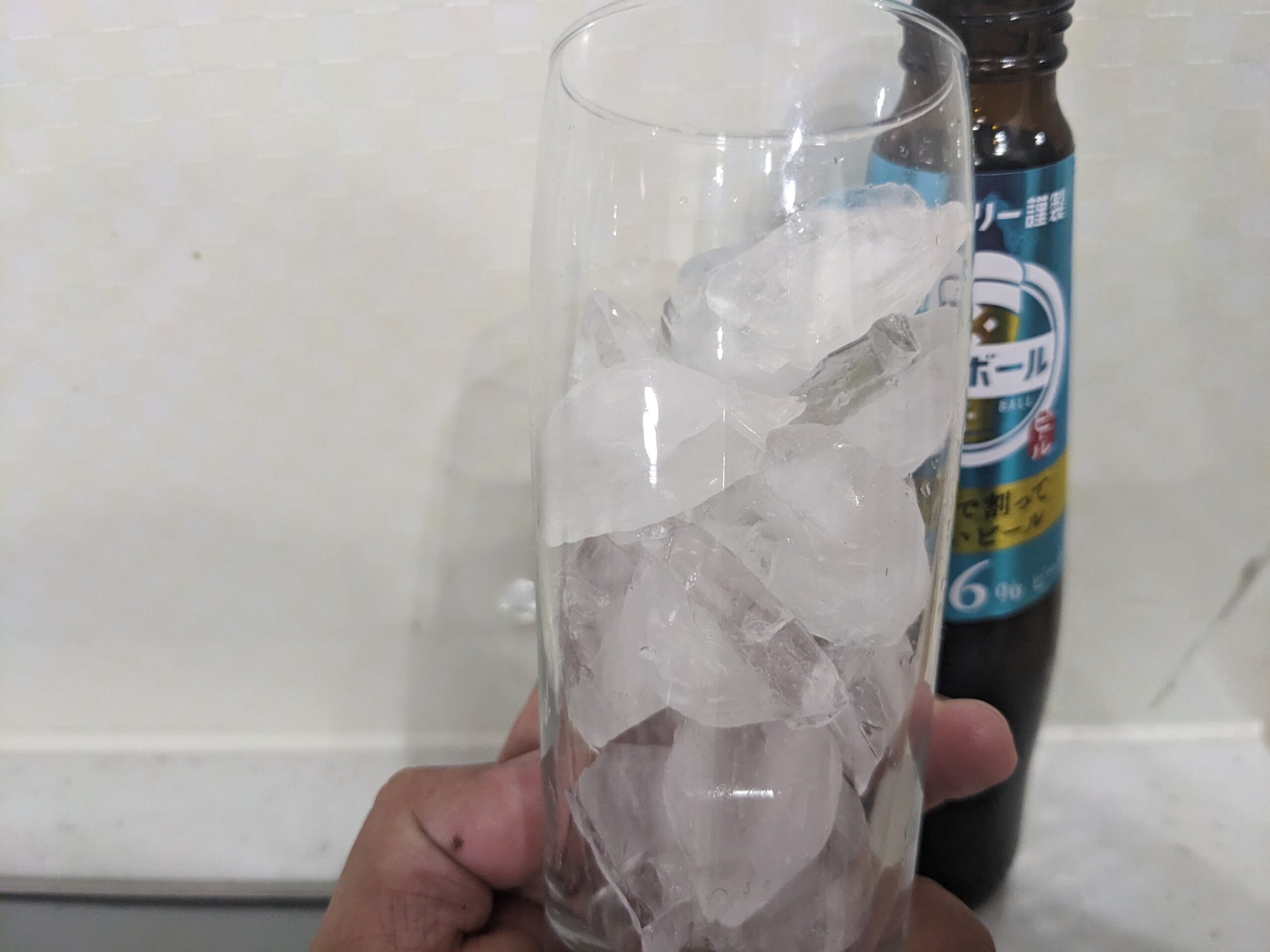 氷が入ったグラスを持っている