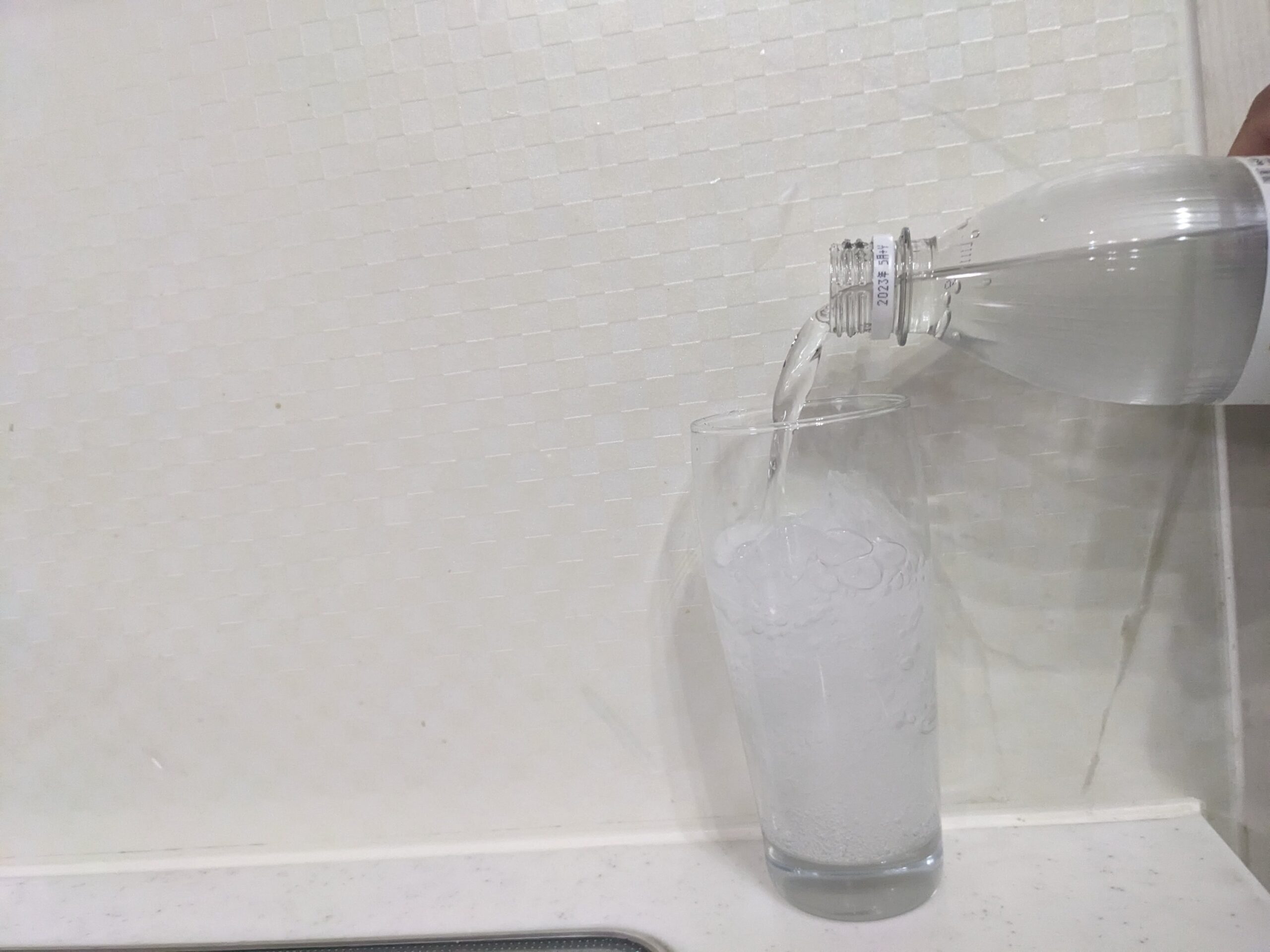グラスに炭酸水を注いでいるところ
