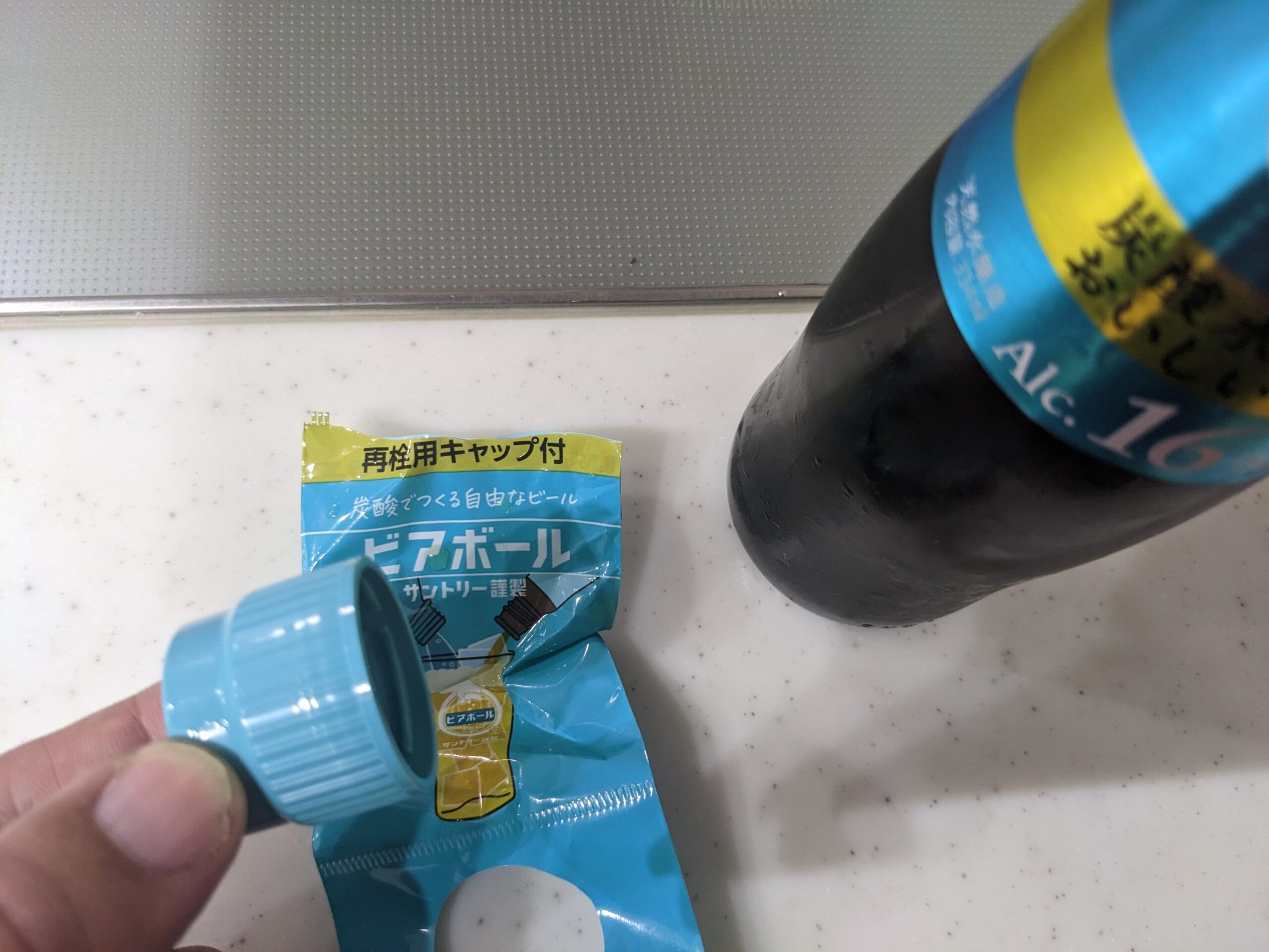 「ビアボール」再栓用キャップを持っているところ