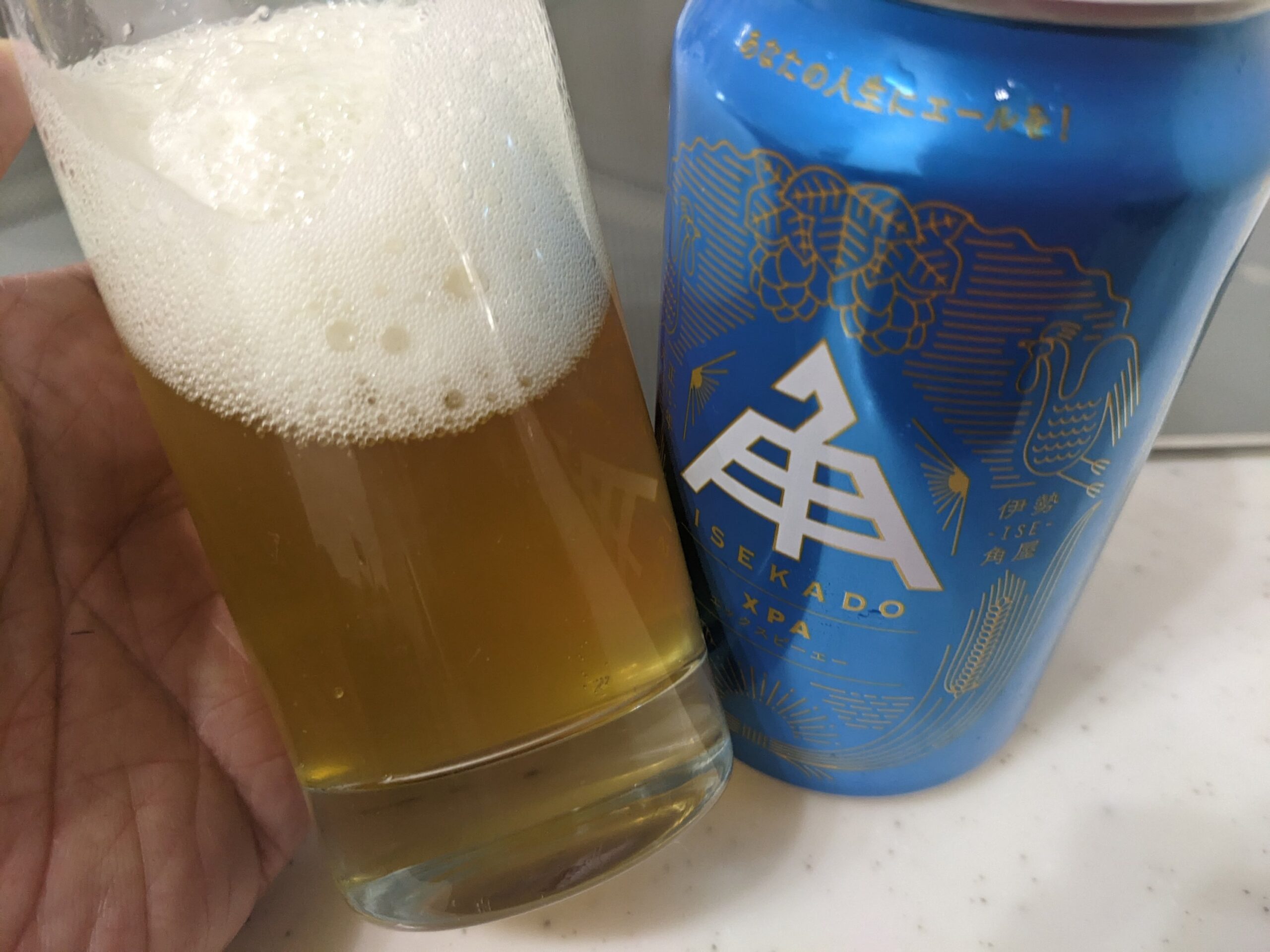 「伊勢角屋麦酒XPA(エックスピーエー)」が入ったグラスを傾けているところ