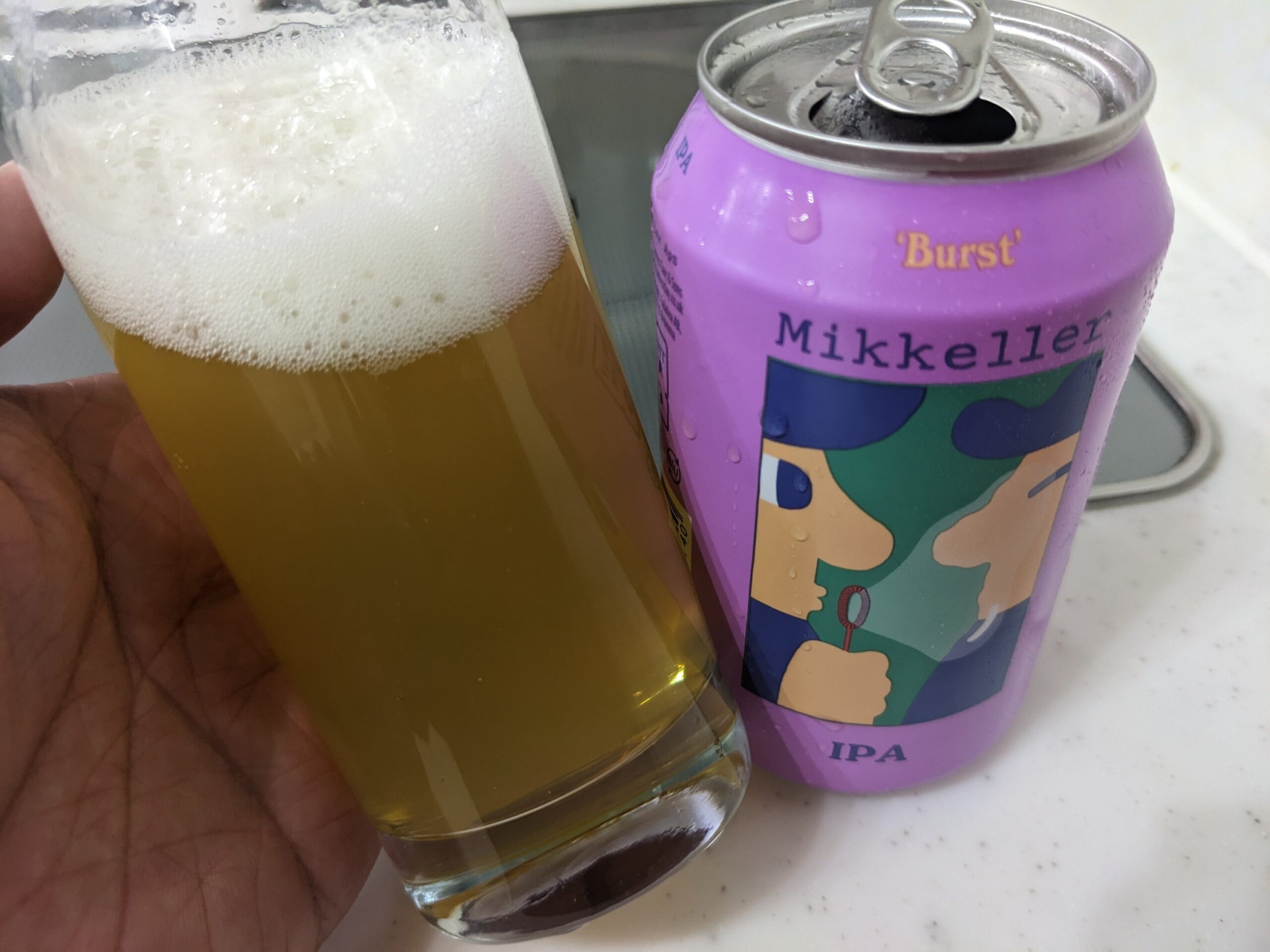 「ミッケラーバーストIPA」が入ったグラスを傾けているところ