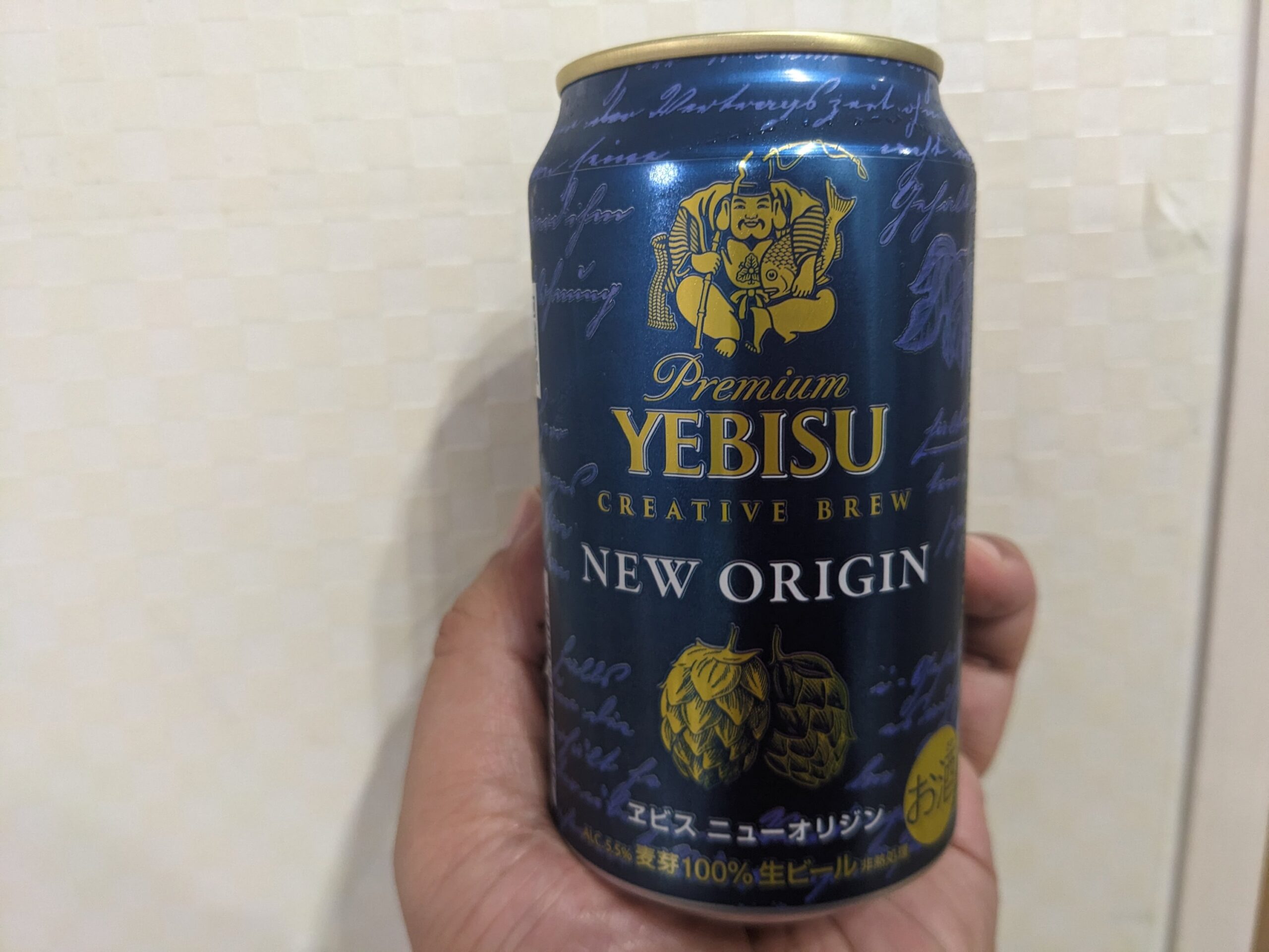 「ヱビスニューオリジン」を手で持っている