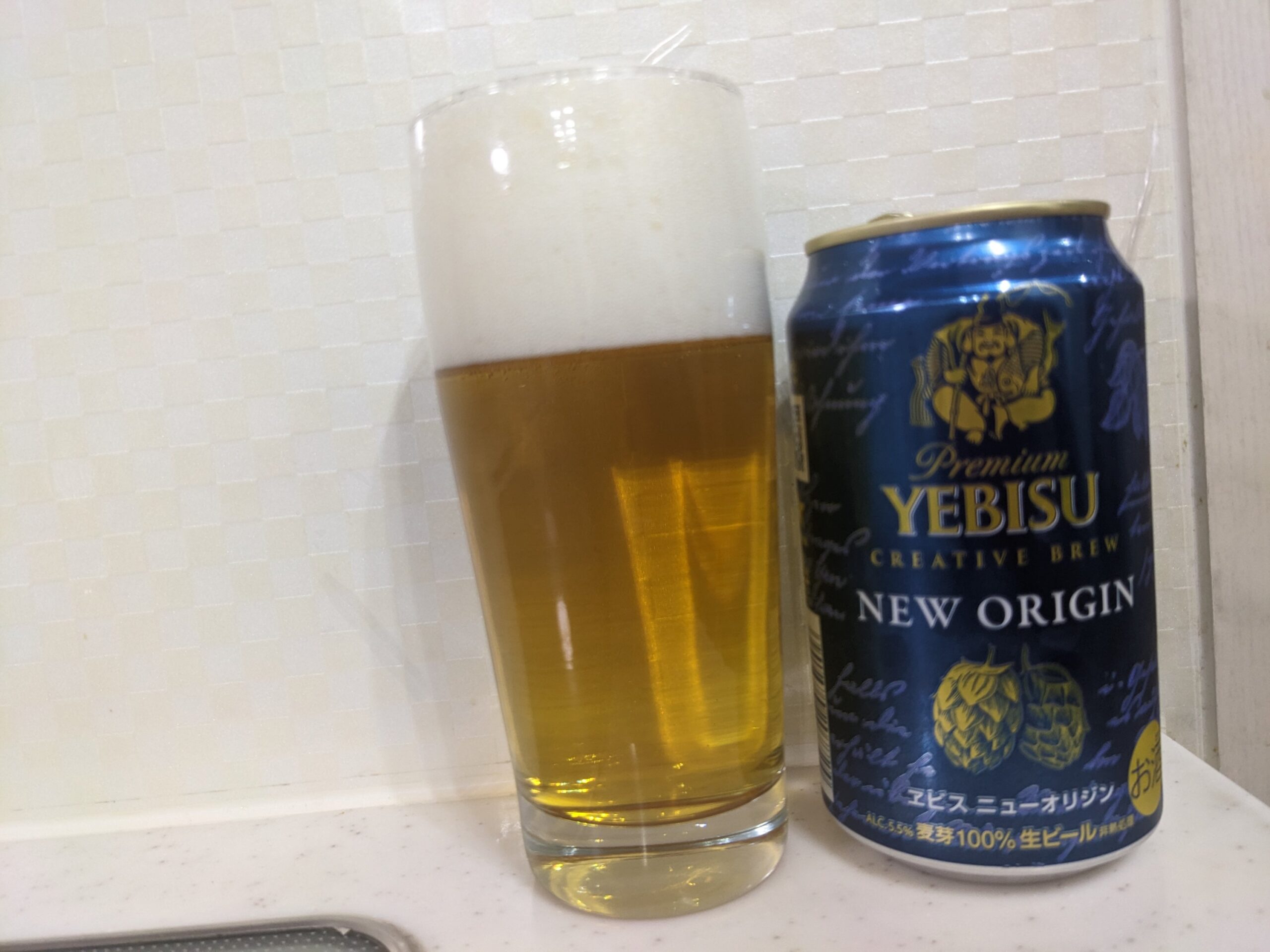 「ヱビスニューオリジン」が注がれたグラスとその缶