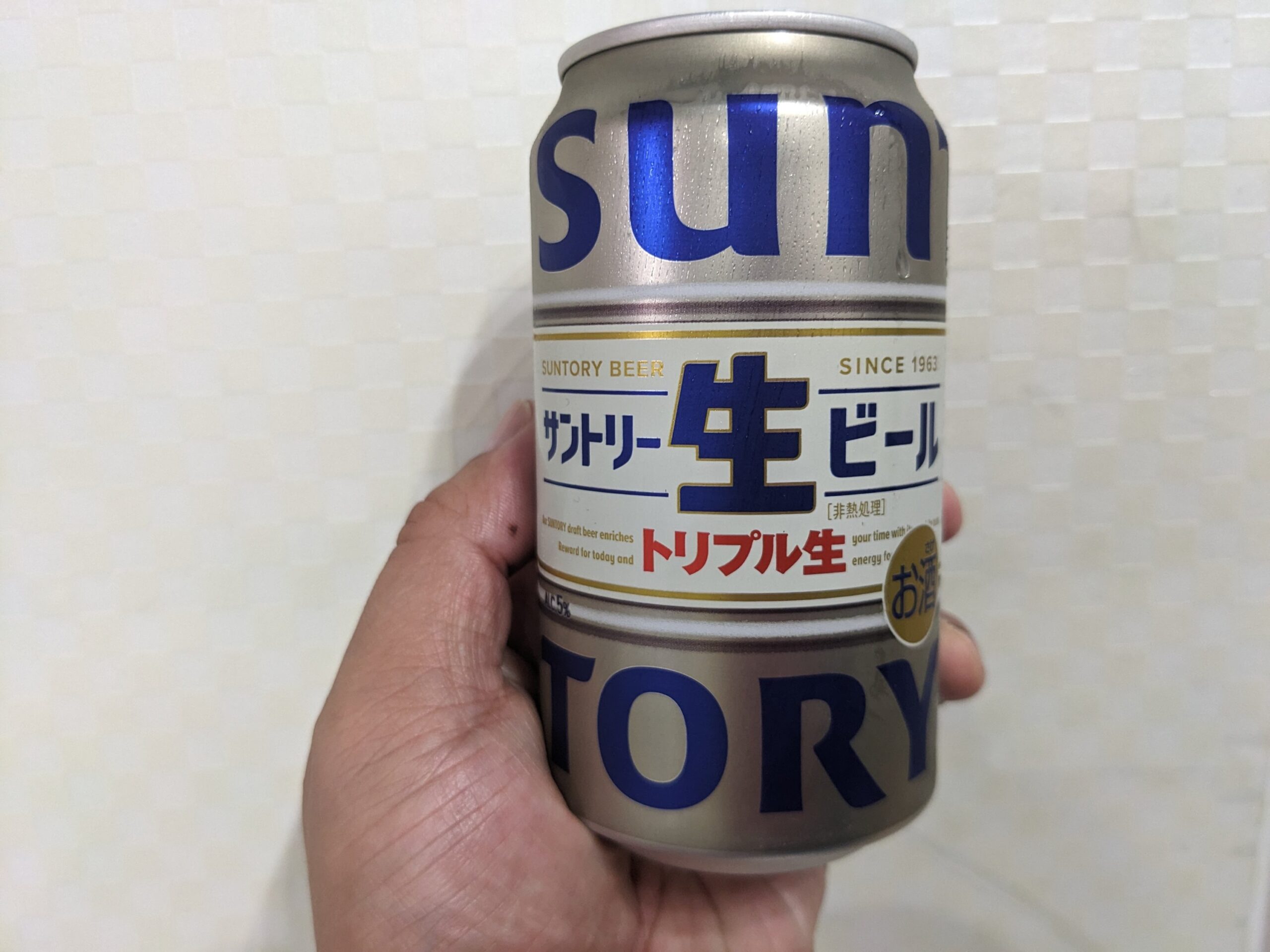 「サントリー生ビールトリプル生」を手で持っている