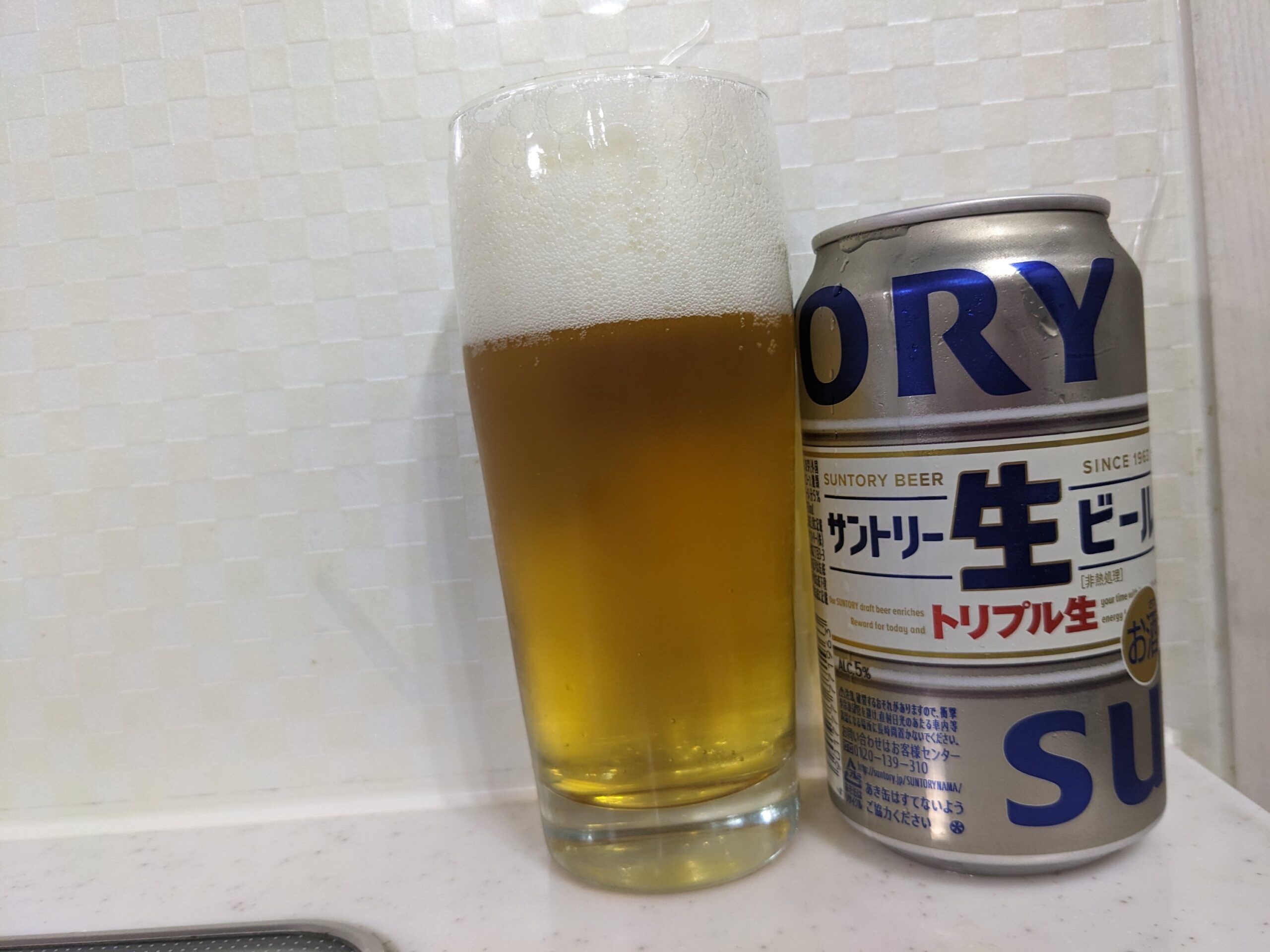 「サントリー生ビールトリプル生」が注がれたグラスとその缶