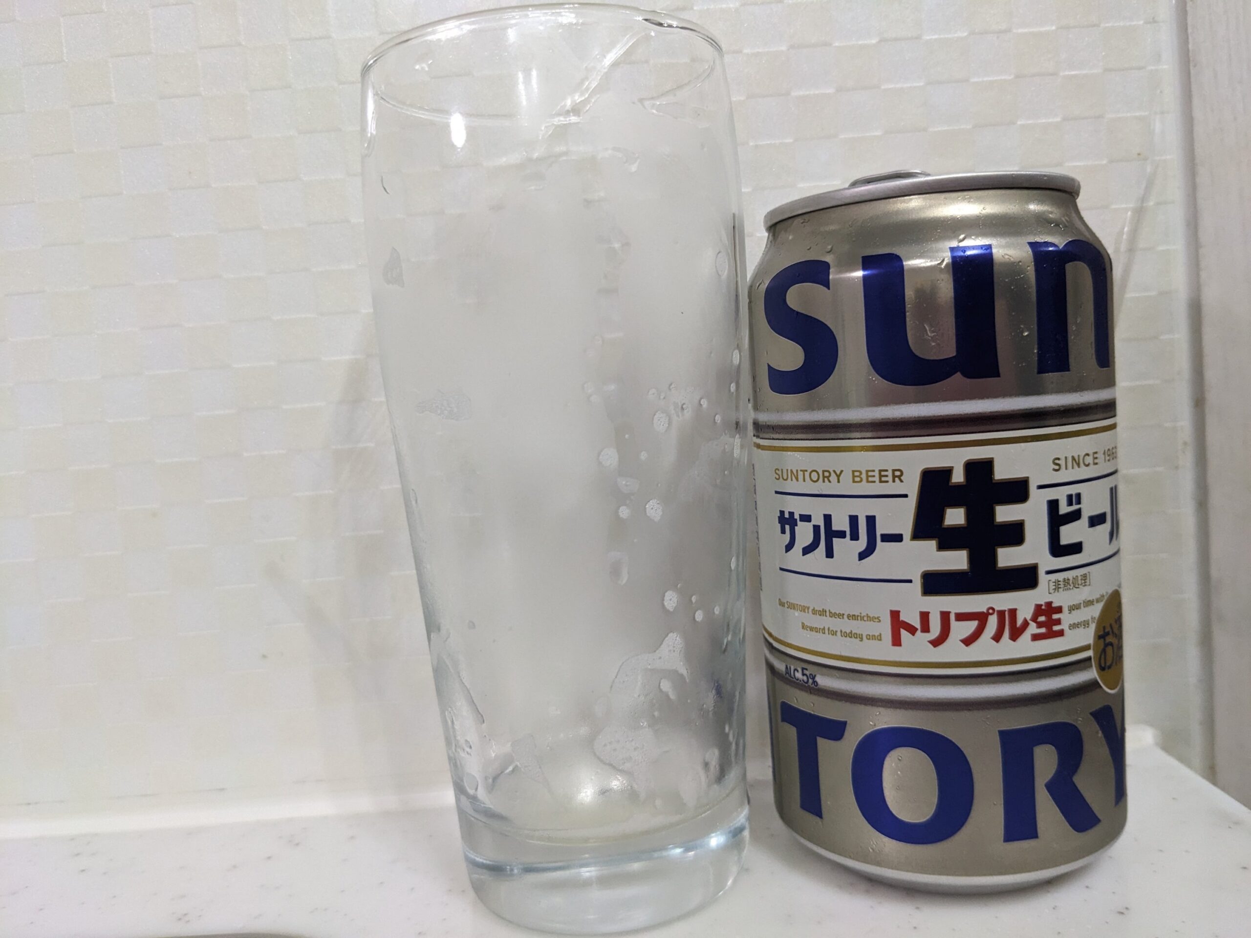 「サントリー生ビールトリプル生」を飲み終えたグラスとその空き缶