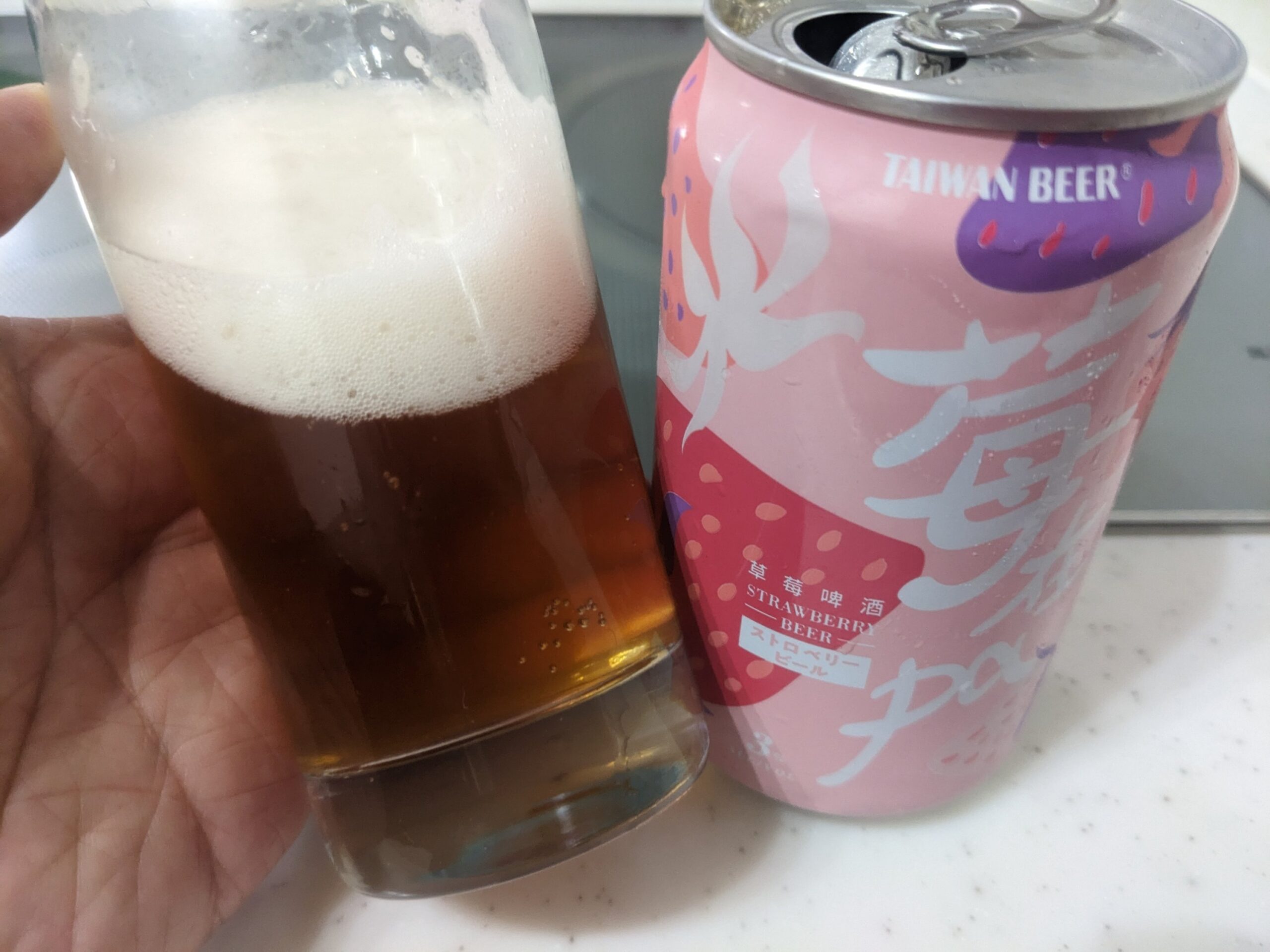 「台湾ストロベリービール（苺在pa）」が入ったグラスを傾けているところ